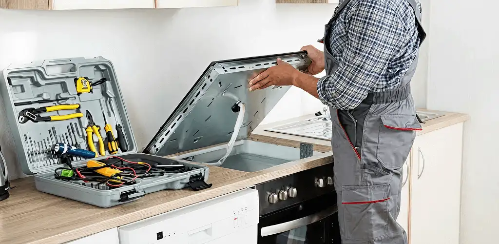 Handyman repairing a cooktop and checking wiring connections in Detroit, MI