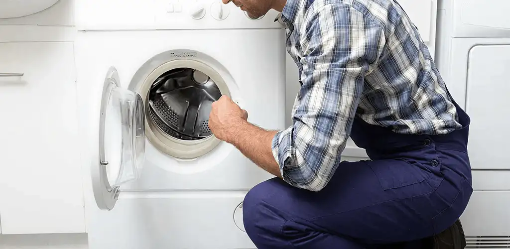 Handyman inspecting a dryer drum and internal parts for repair in Detroit, MI