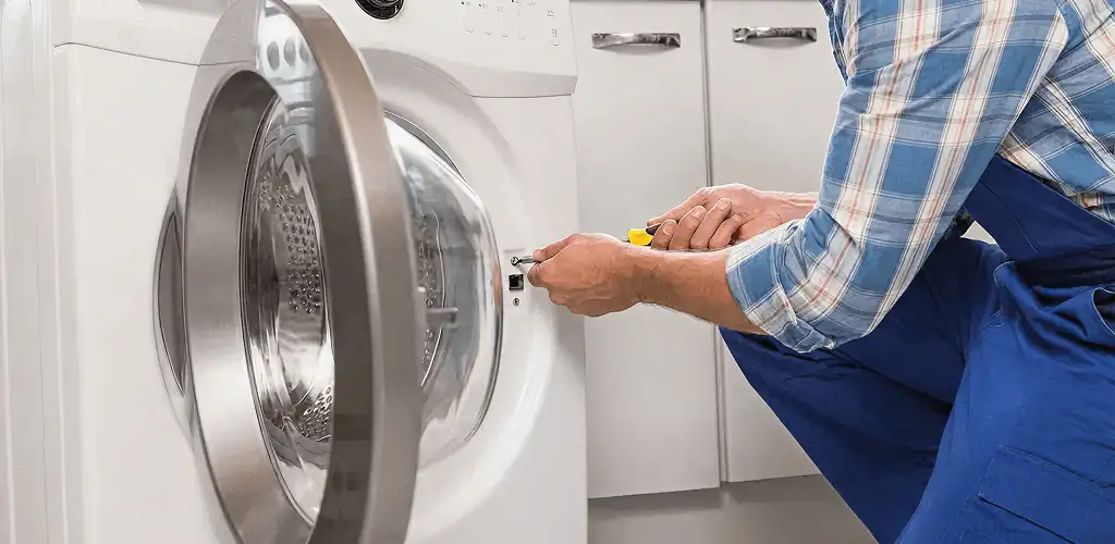 Handyman repairing a clothes dryer and checking electrical connections in Detroit, MI