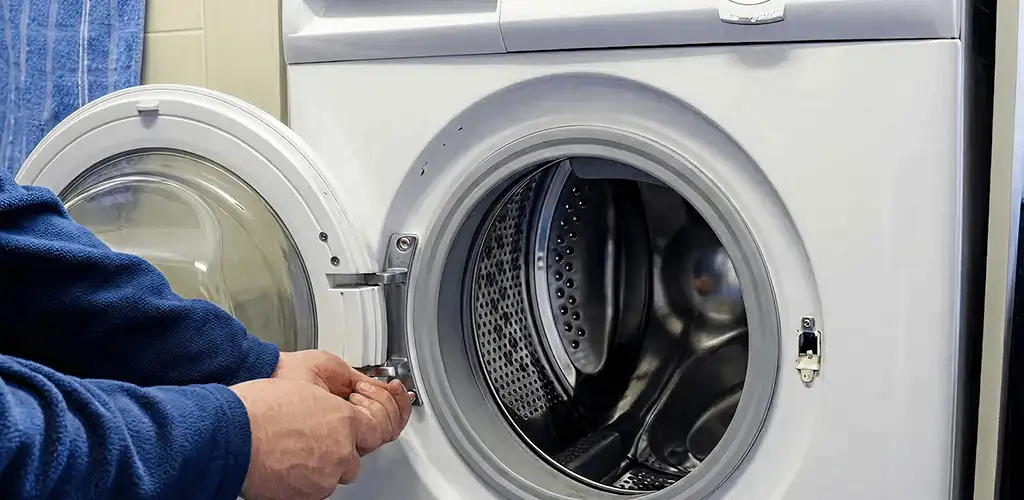 Washing machine repair handyman checking a front-load washer door and latch in Detroit, MI