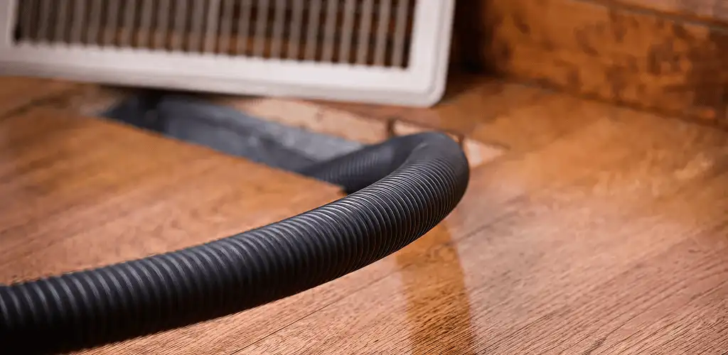 Air duct cleaning hose inserted into a floor vent for ductwork cleaning in Detroit, MI