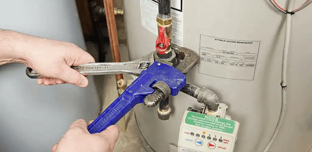 Water heater repair technician tightening the shutoff valve and supply line in Detroit, MI