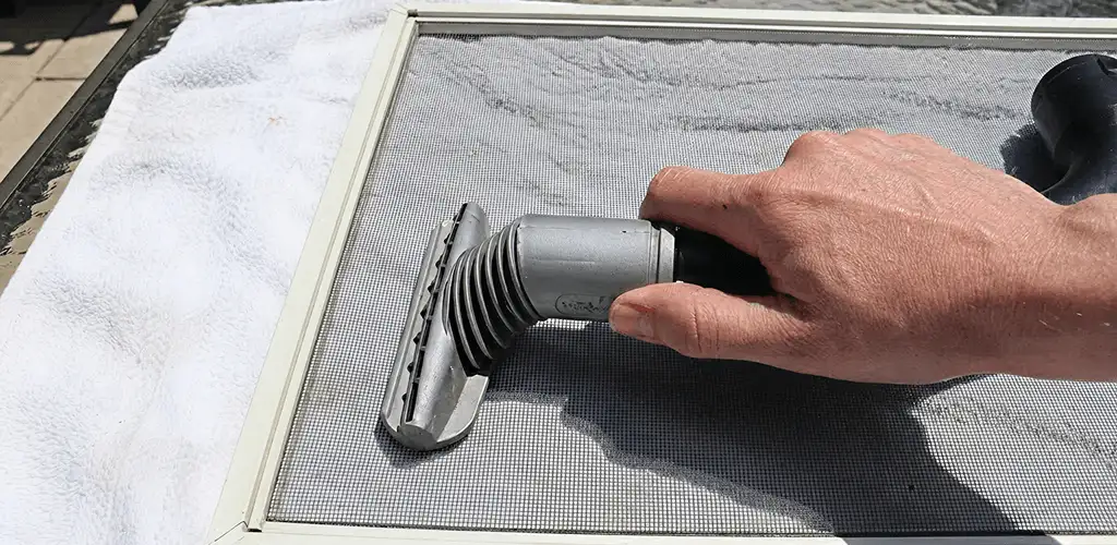 Window screen repair cleaning and fixing a damaged screen mesh in Detroit, MI